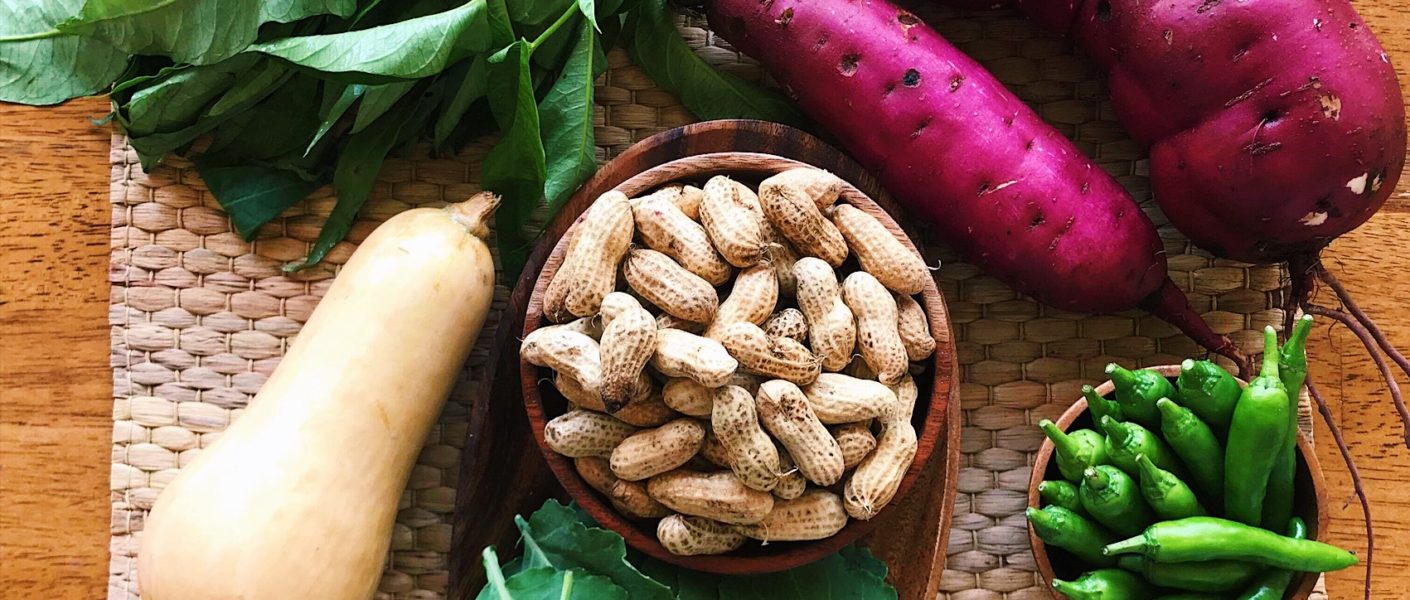 swee potatoes, squash, greens, peanuts laid out on bamboo mat