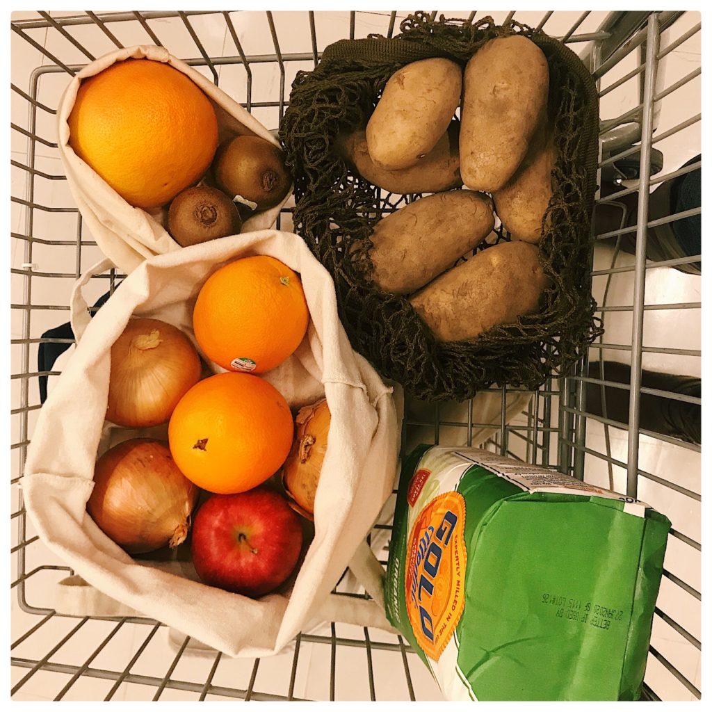 produce in cloth bags in shopping cart 