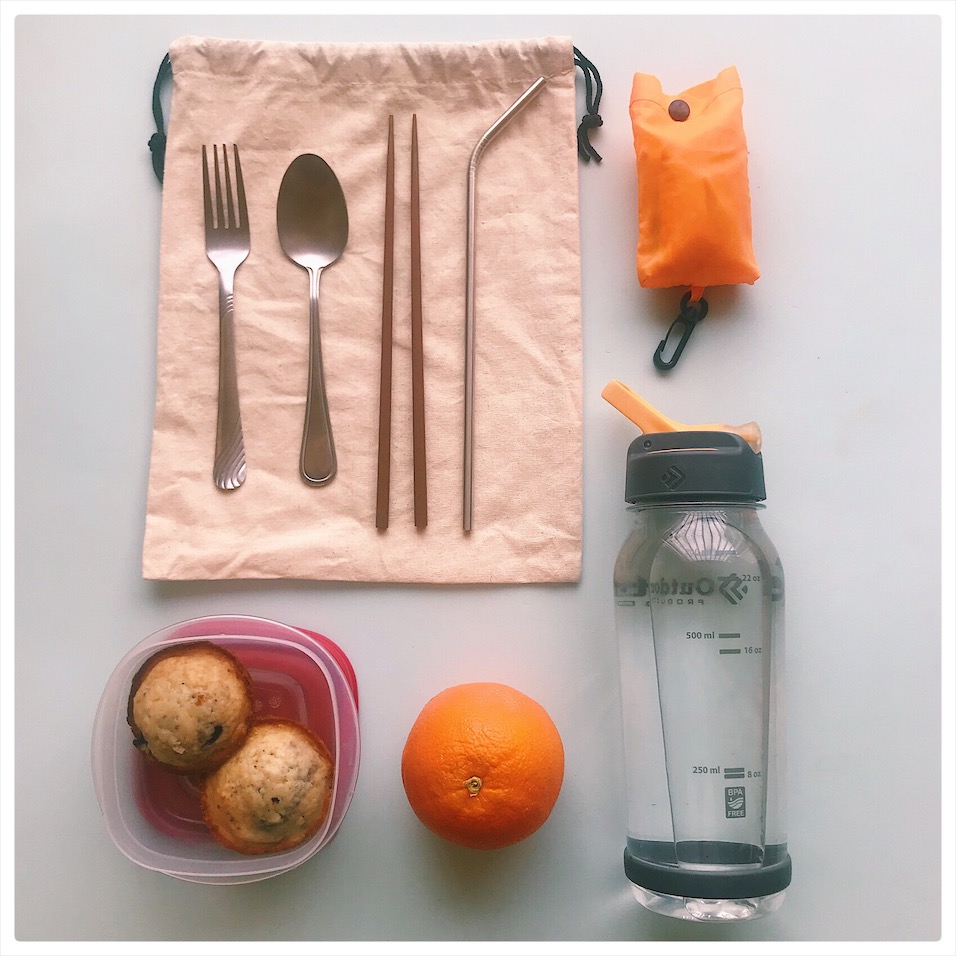 utensils, water bottle, reusable bags and snacks on table